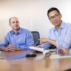 The Prothena team having a conversation at a table.