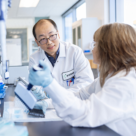 Two scientists having a conversation at a lab.