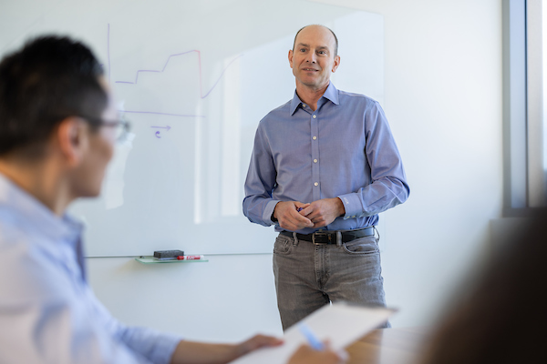 Gene Kinney, Prothena CEO, presenting in front of a whiteboard.